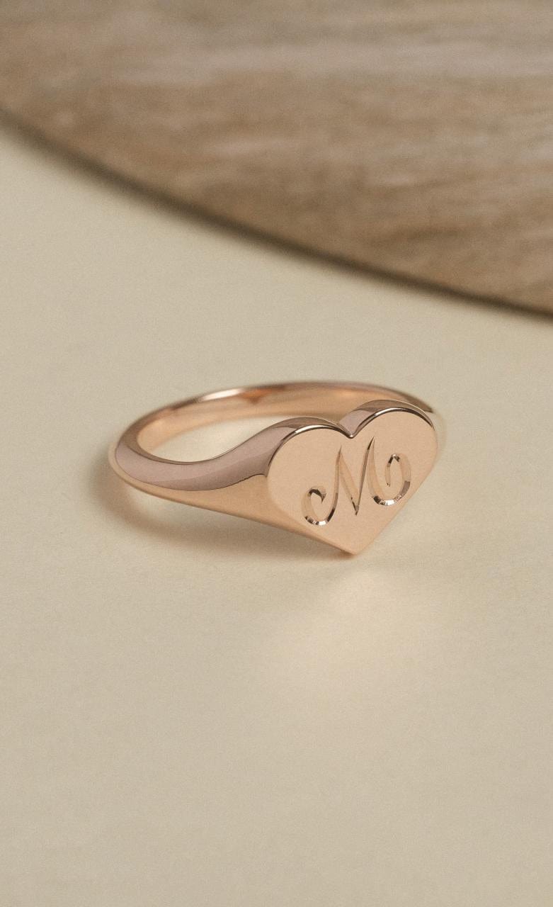 9k rose gold heart shaped signet ring with an M initial engraved into the face.